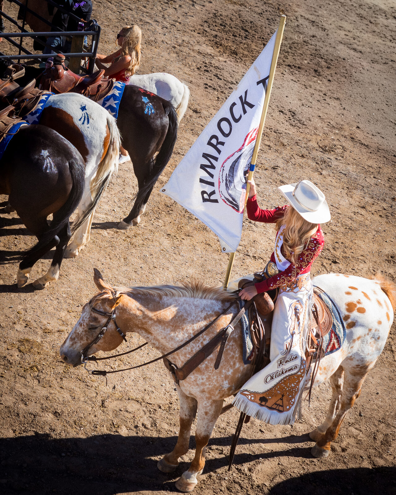 A rodeo queen carries the colors