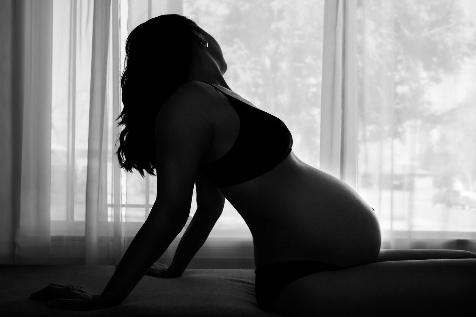 Maternity silhouette in window light