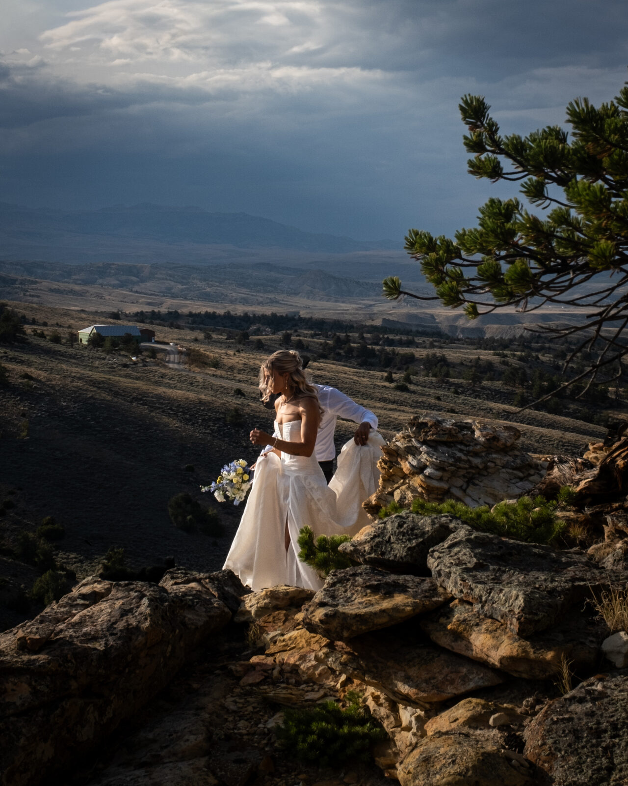 A couple on a rocky overlook under a stormy sky