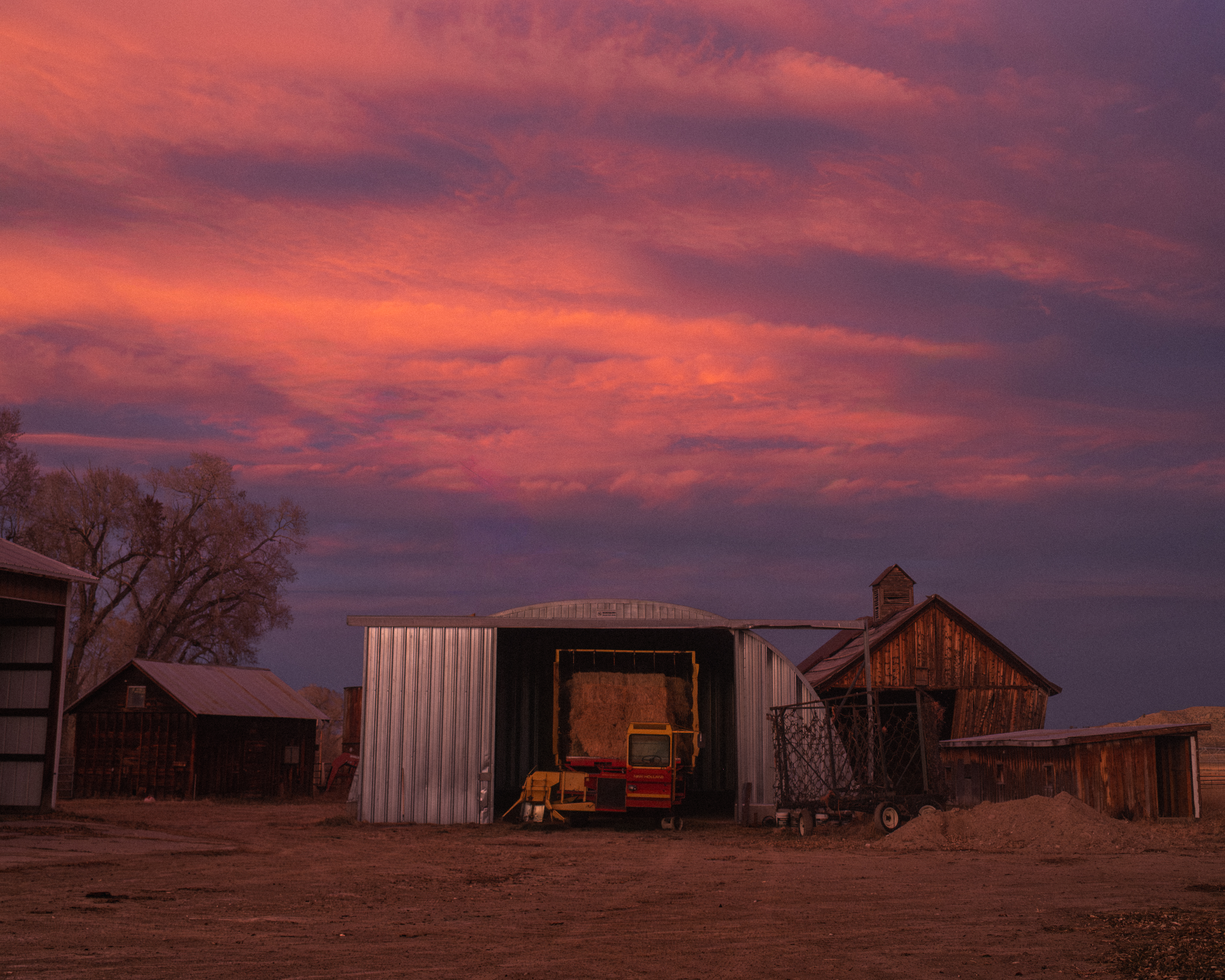 A ranch yard under a pink and violet sunset